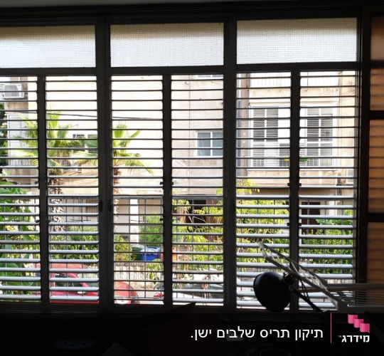 תריסים אופקיים על חלון גדול עם נוף חיצוני